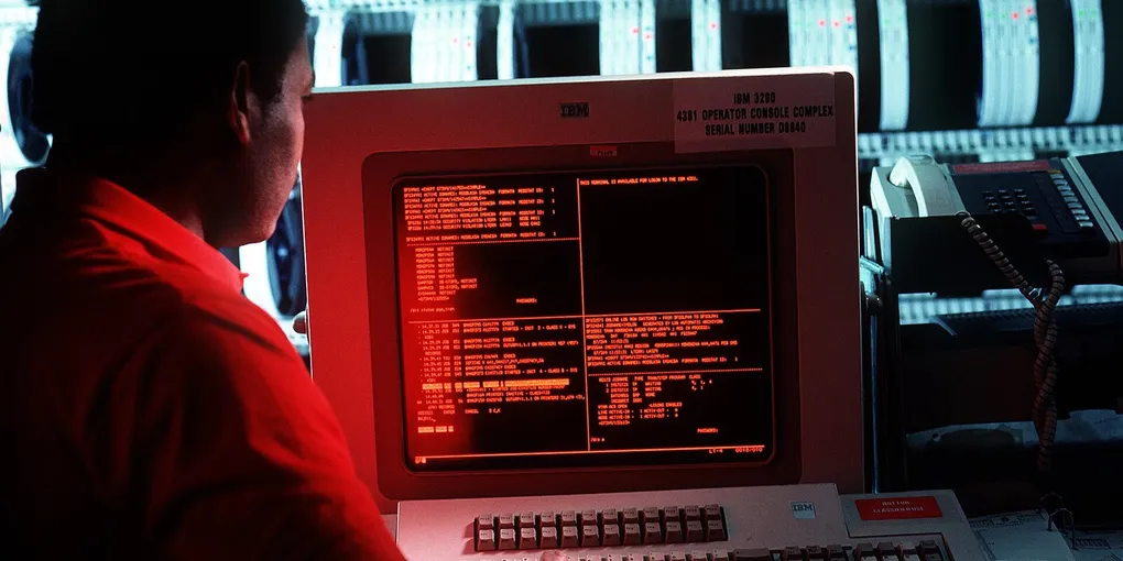 Operator at an IBM 4381 terminal in a mainframe computer room