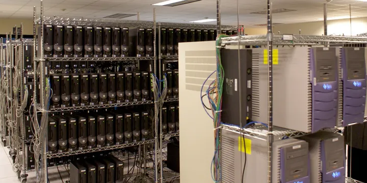 Rows of physical servers and network cables on metal racks in the Centaur server room